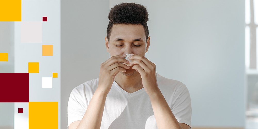 Person blowing their nose into a tissue