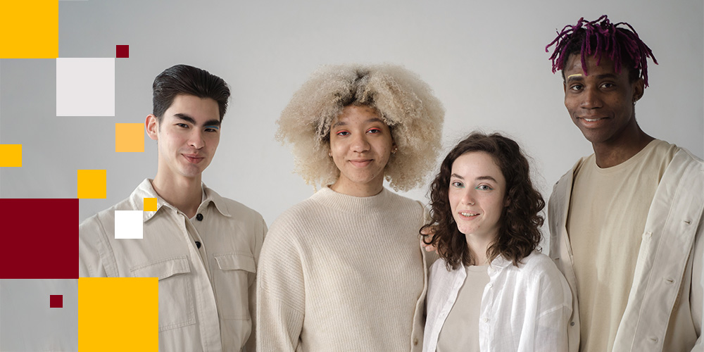 A group of four people in front of a neutral grey background