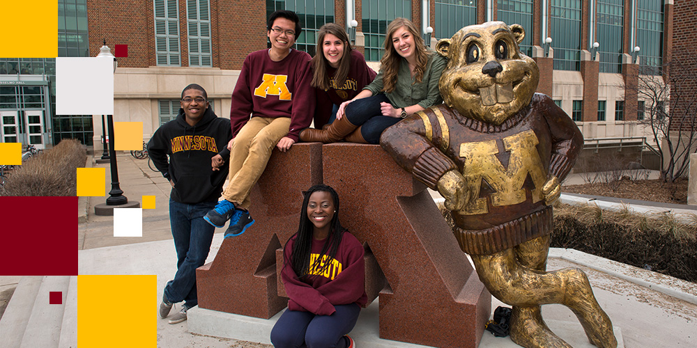 Students pose in front of the Goldy statue