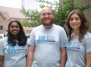 3 students stand together as health advocates smiling for the camera
